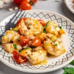 A plate of shrimp with tomatoes and feta.