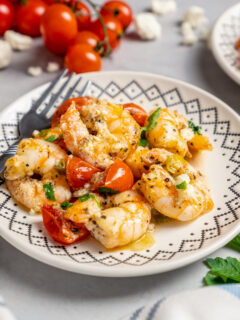 A plate of shrimp with tomatoes and feta.