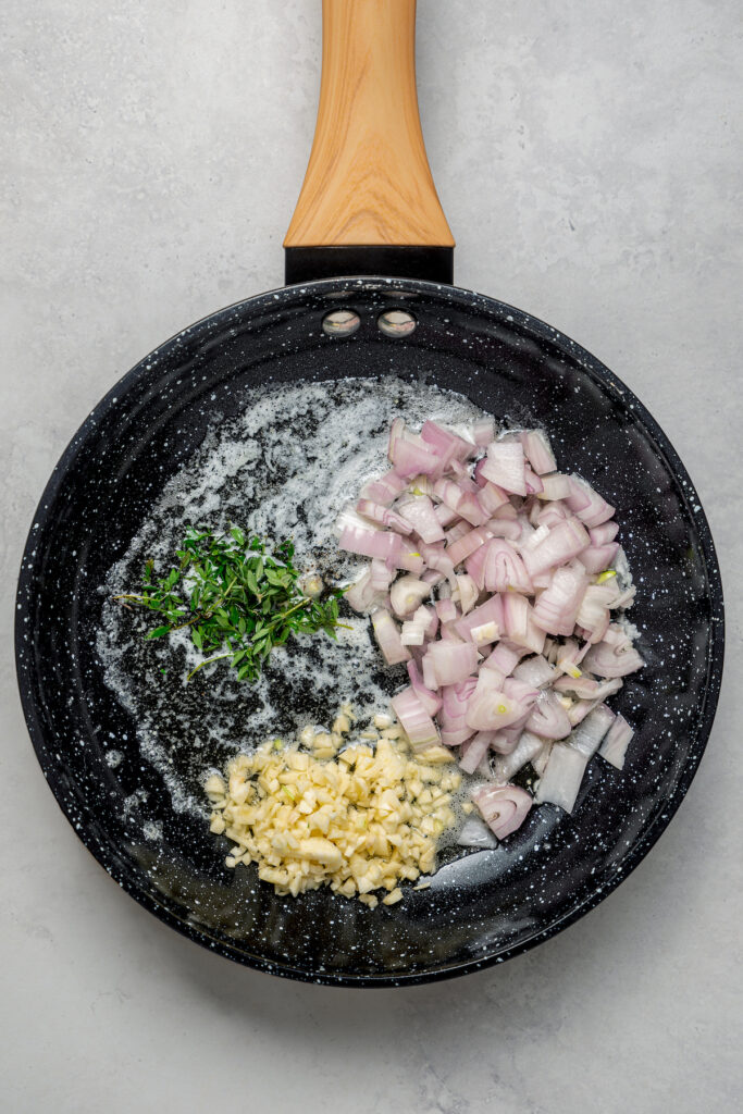 Cooking garlic, shallots, and parsley in a skillet.