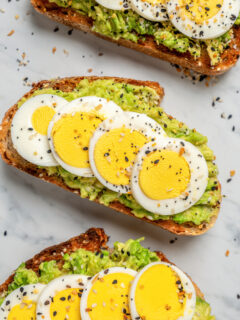 Slices of avocado toast topped with eggs.