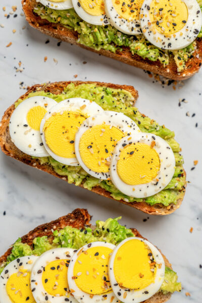 Slices of avocado toast topped with eggs.