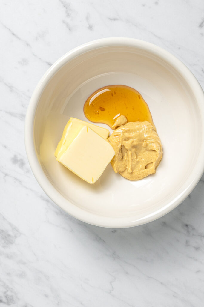 Butter, honey, and Dijon in a small bowl.