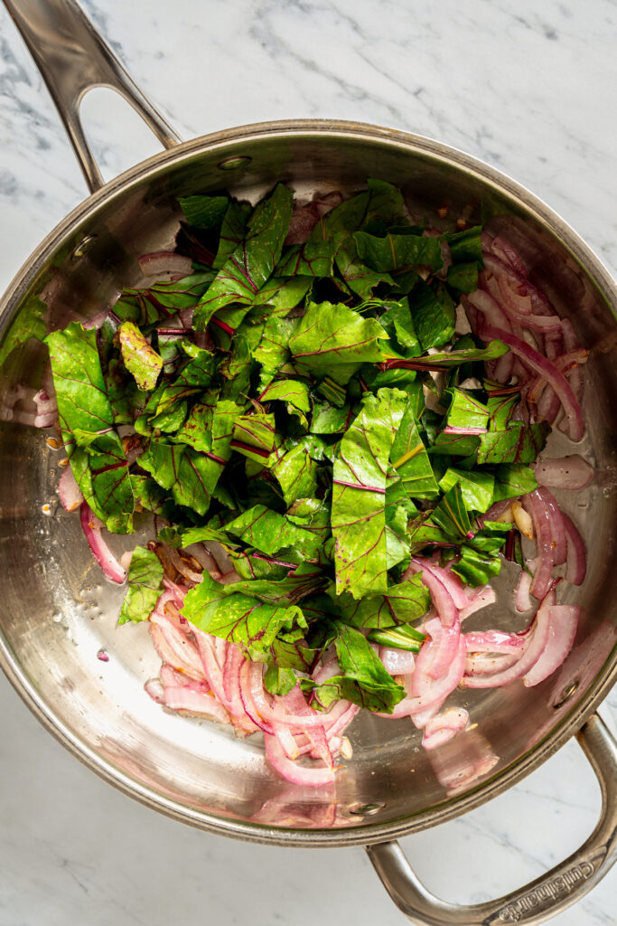 Wilting beet greens in a pan.