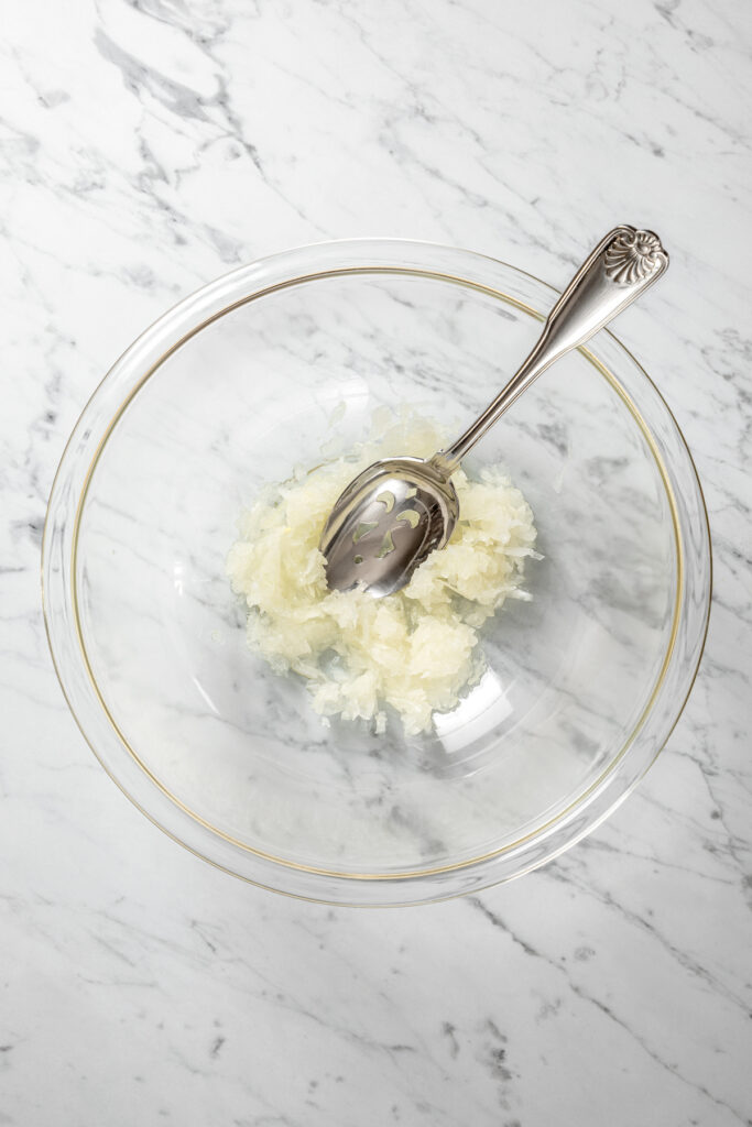 Grated onion in a mixing bowl.