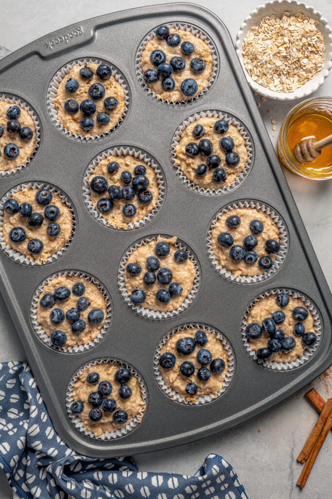 Liners filled with batter and topped with fresh blueberries. 