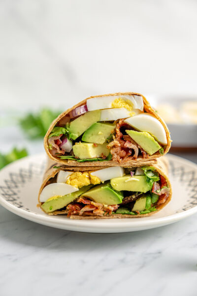 Egg and avocado breakfast wrap on a plate.