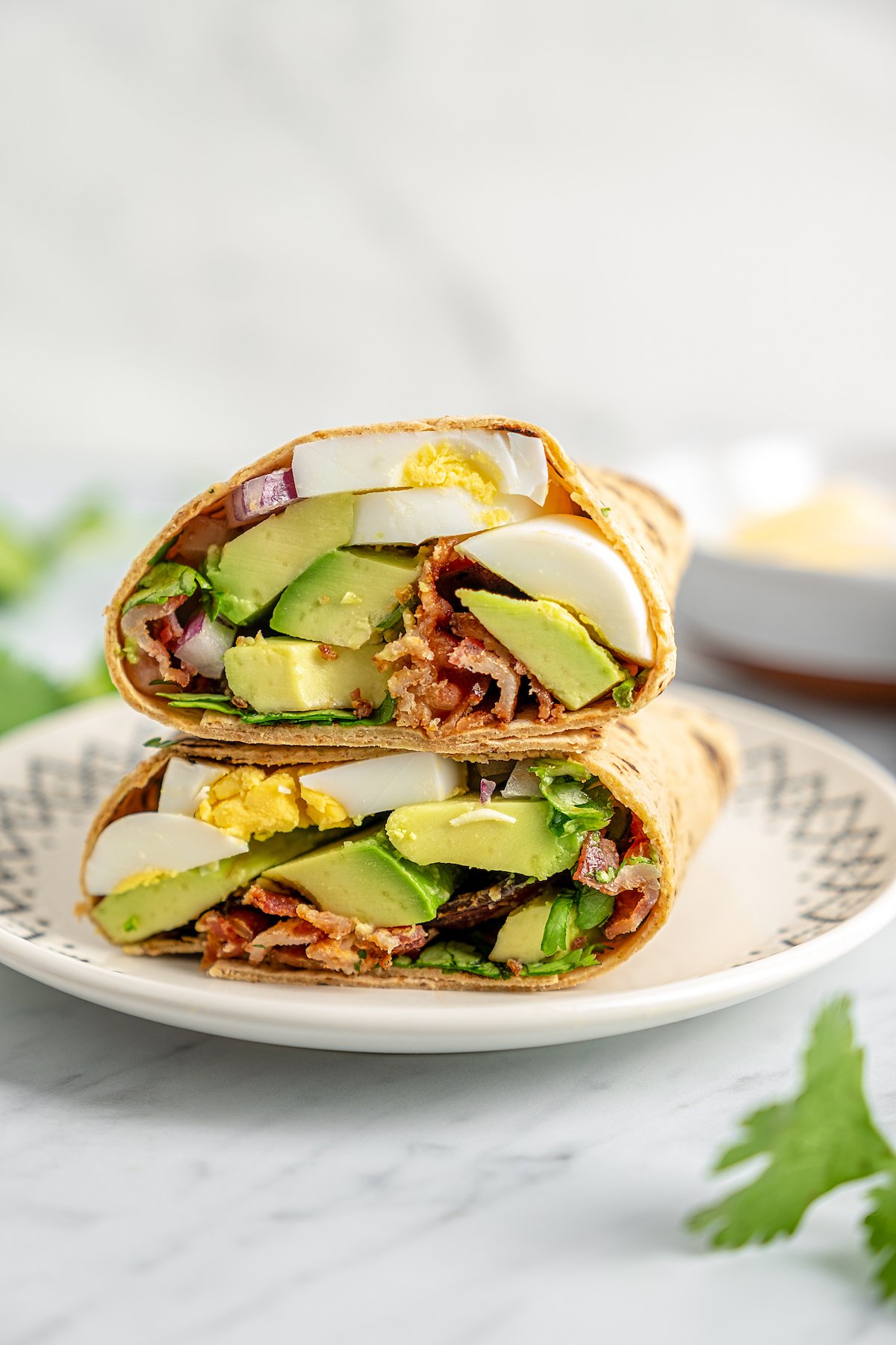A homemade breakfast wrap with hard boiled eggs and avocado.