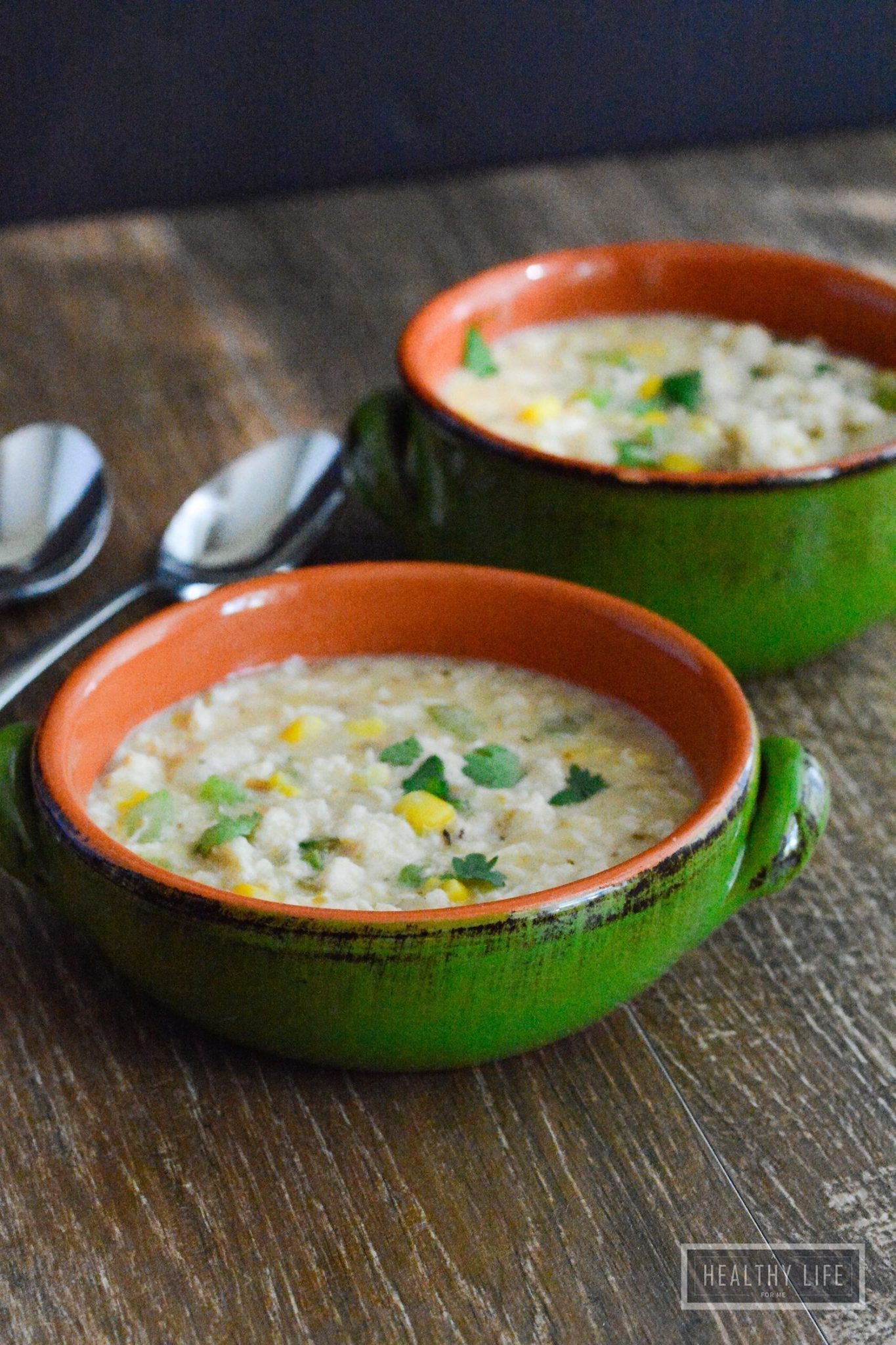 Two bowls of crab chowder with cilantro on top.