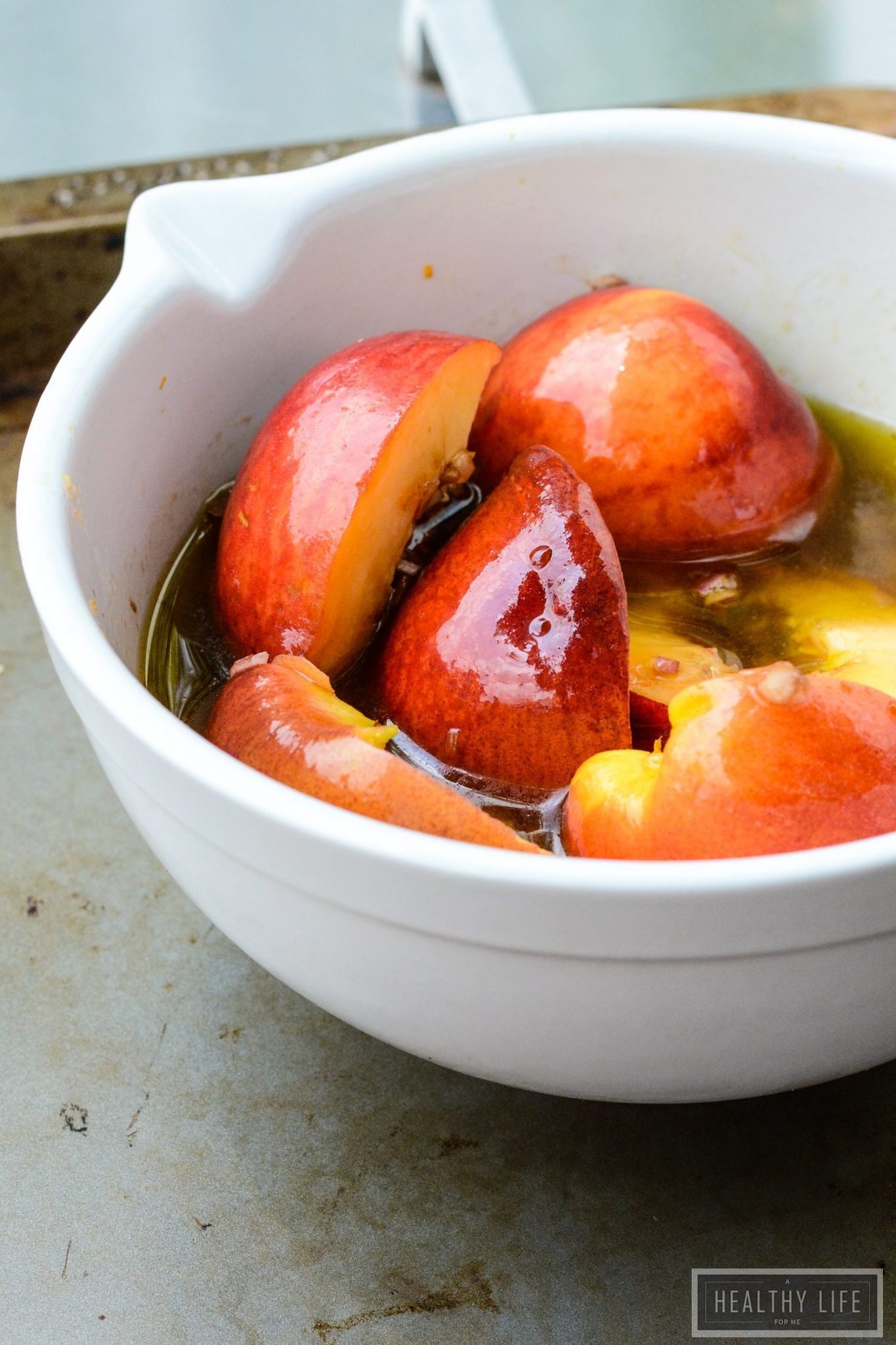 Grilled peaches in bowl of vinaigrette