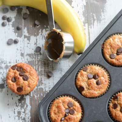 Protein muffins with a measuring spoon and a banana on the side.
