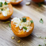 3 Apricots with Goat Cheese and Almond placed on a wooden board