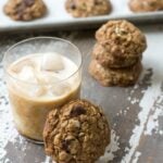 Healthy trail mix cookie set next to iced coffee glass