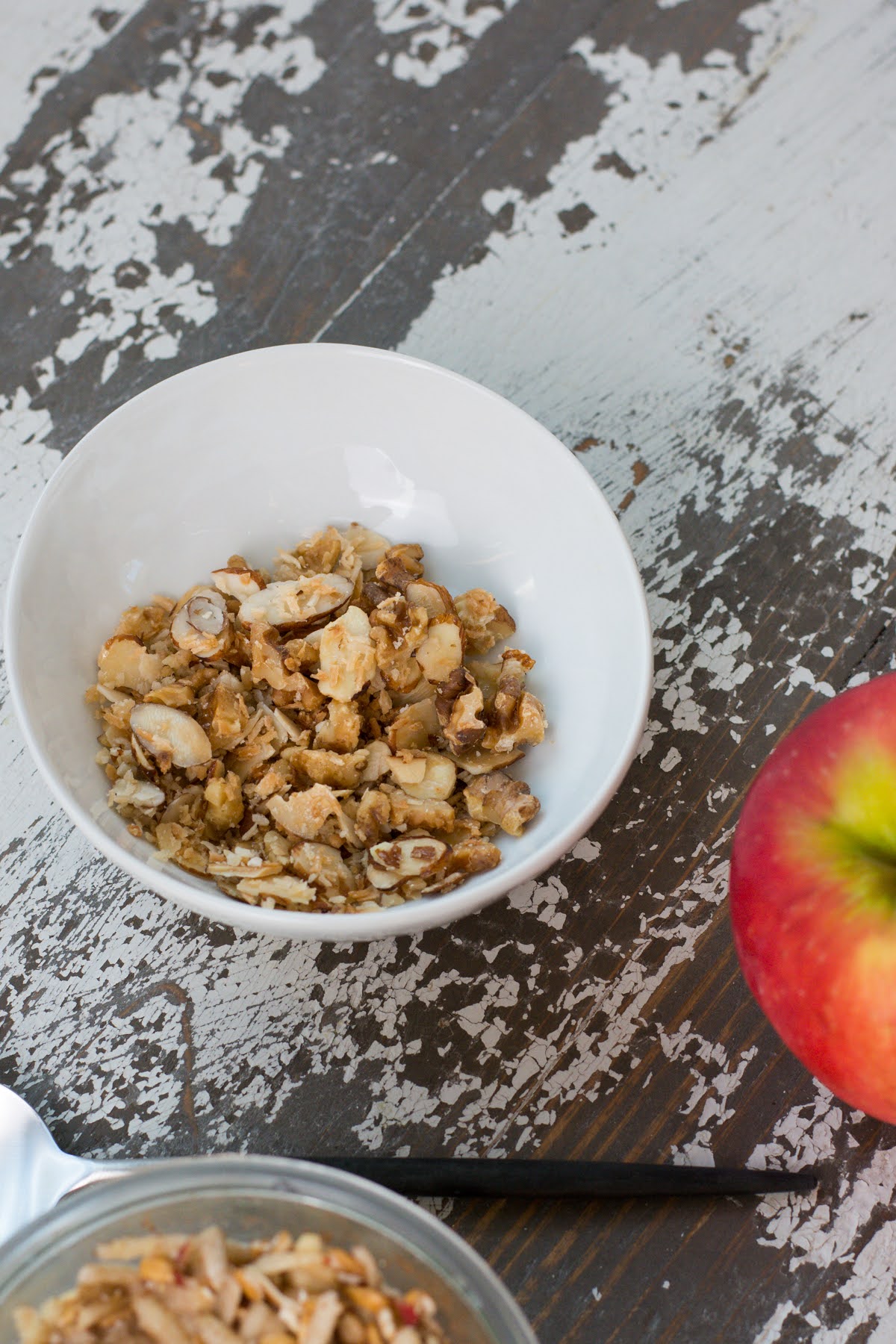 The crisp topping in a small bowl beside a fresh apple