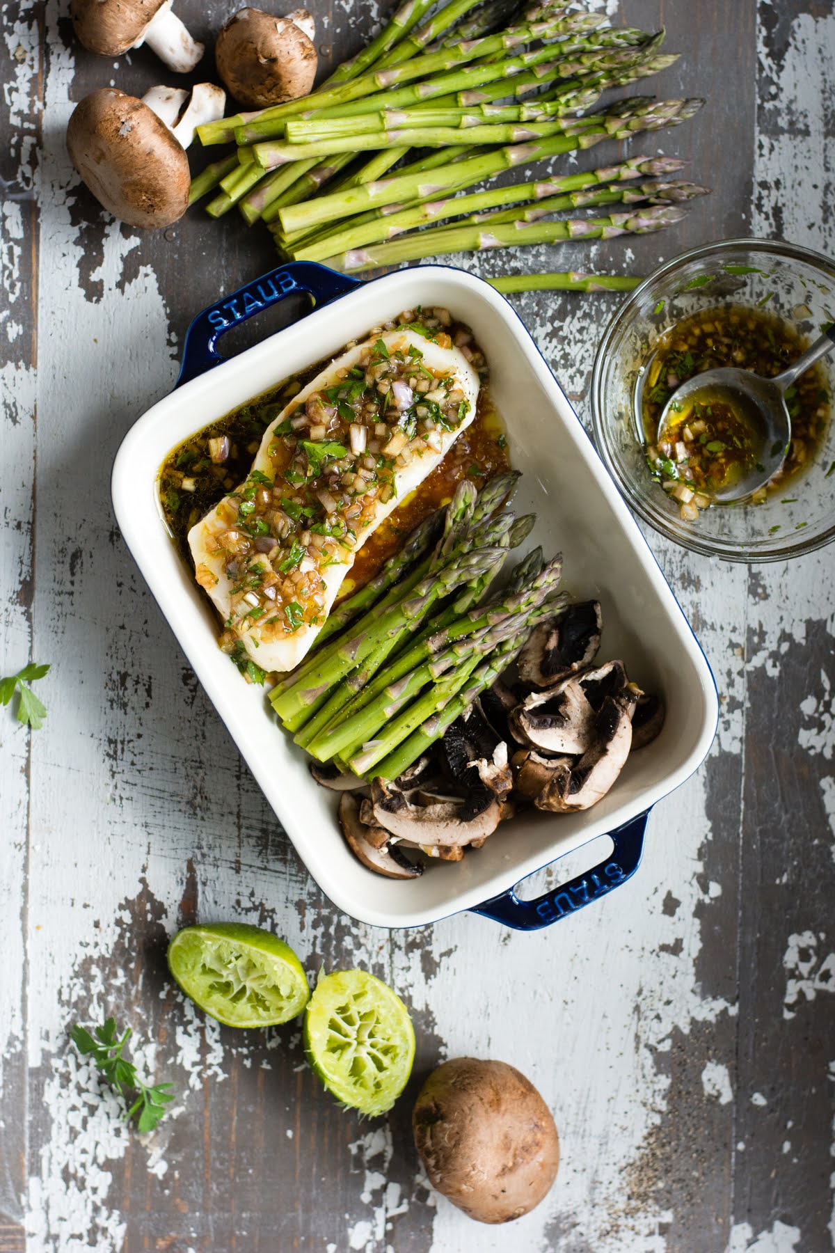 Marinated Chilean sea bass, asparagus, and mushrooms in a baking dish