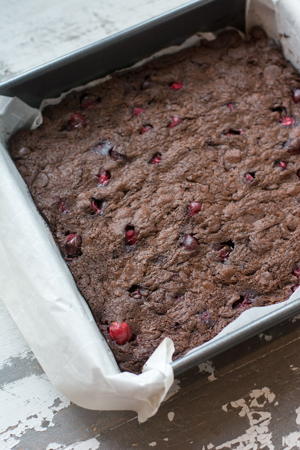Baked brownies with cranberries in a square baking pan.