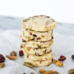 A stack of cookies with cranberries and pistachios.