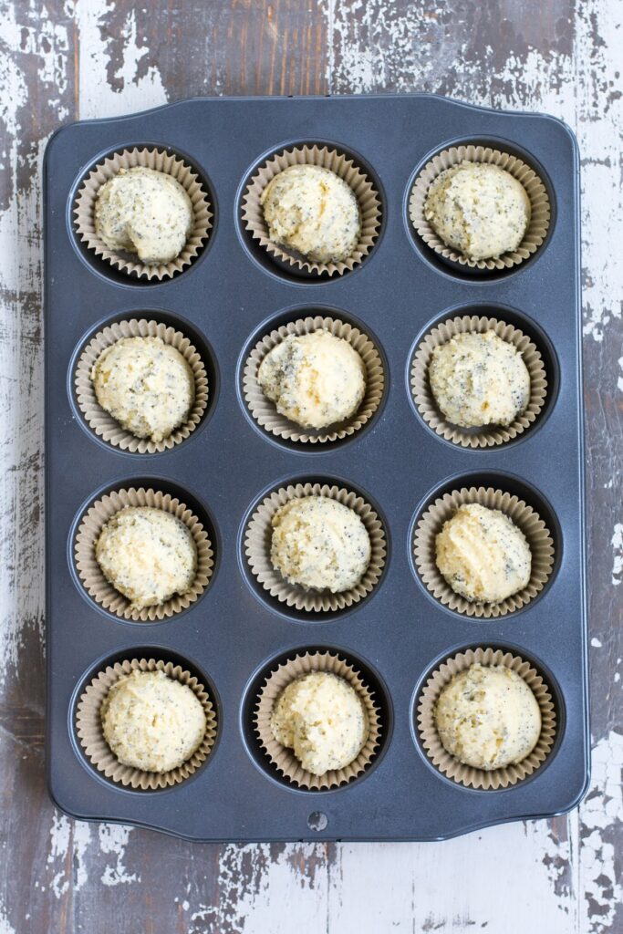 Muffin batter added to a muffin tin with liners.
