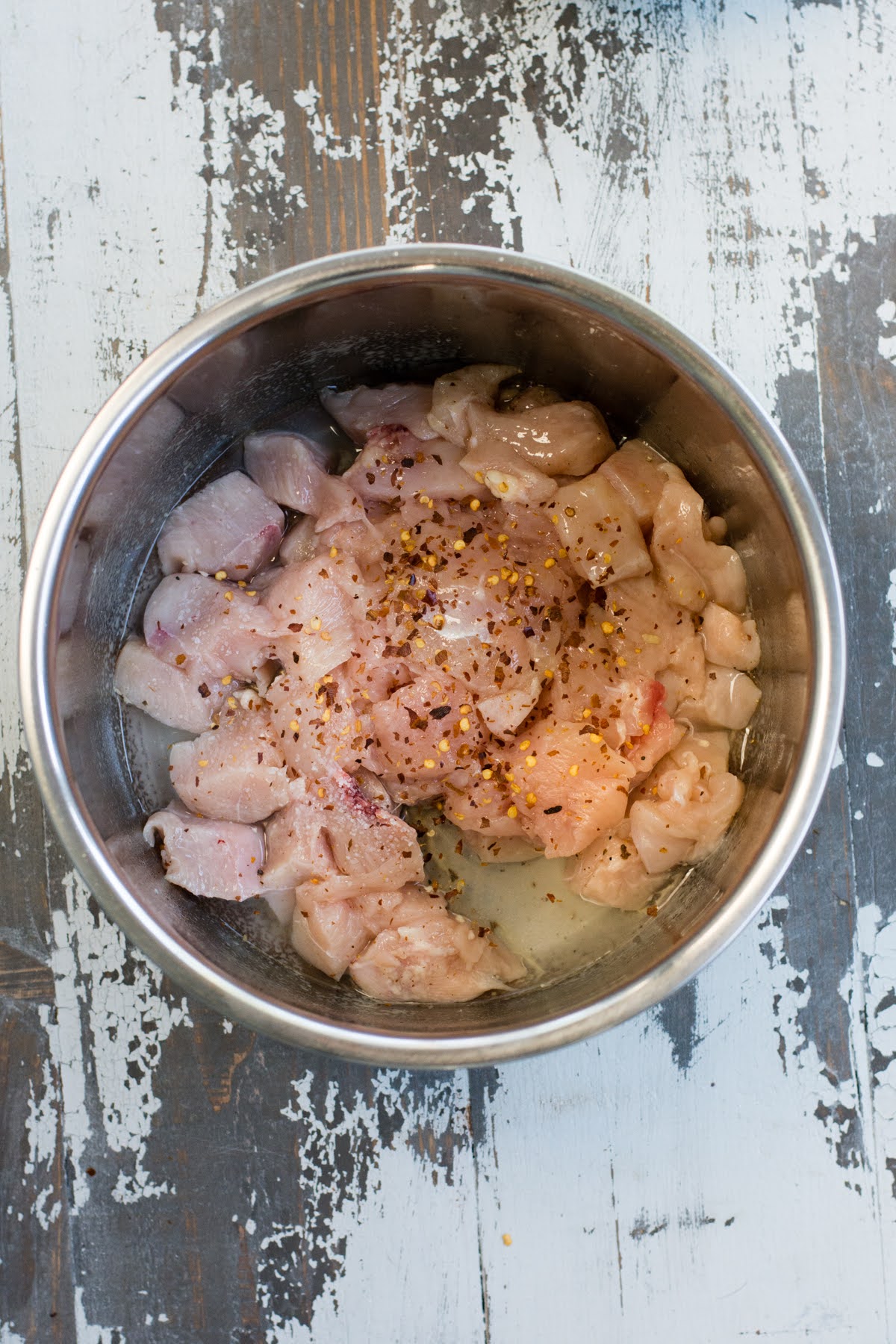 Chicken with salt and pepper in a bowl.