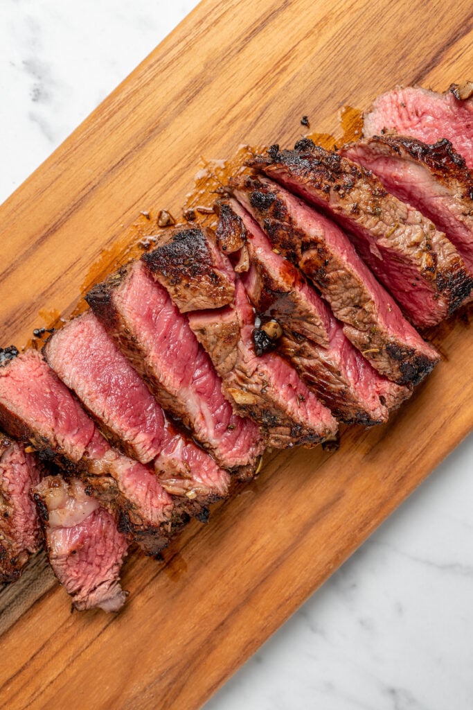 Sliced steak on a cutting board.