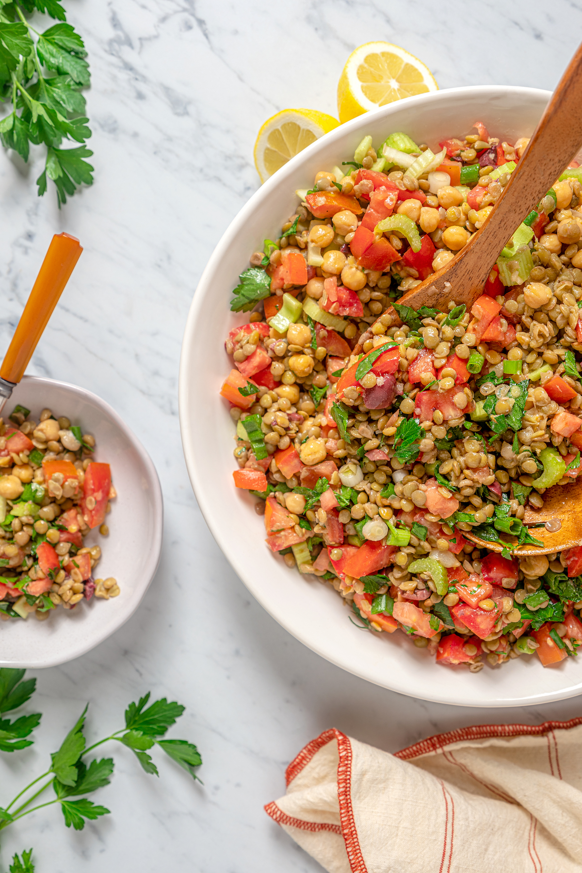 A small plate of lentil salad with a larger bowl of the salad.