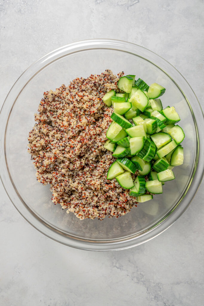 Cucumber added to a bowl of quinoa.
