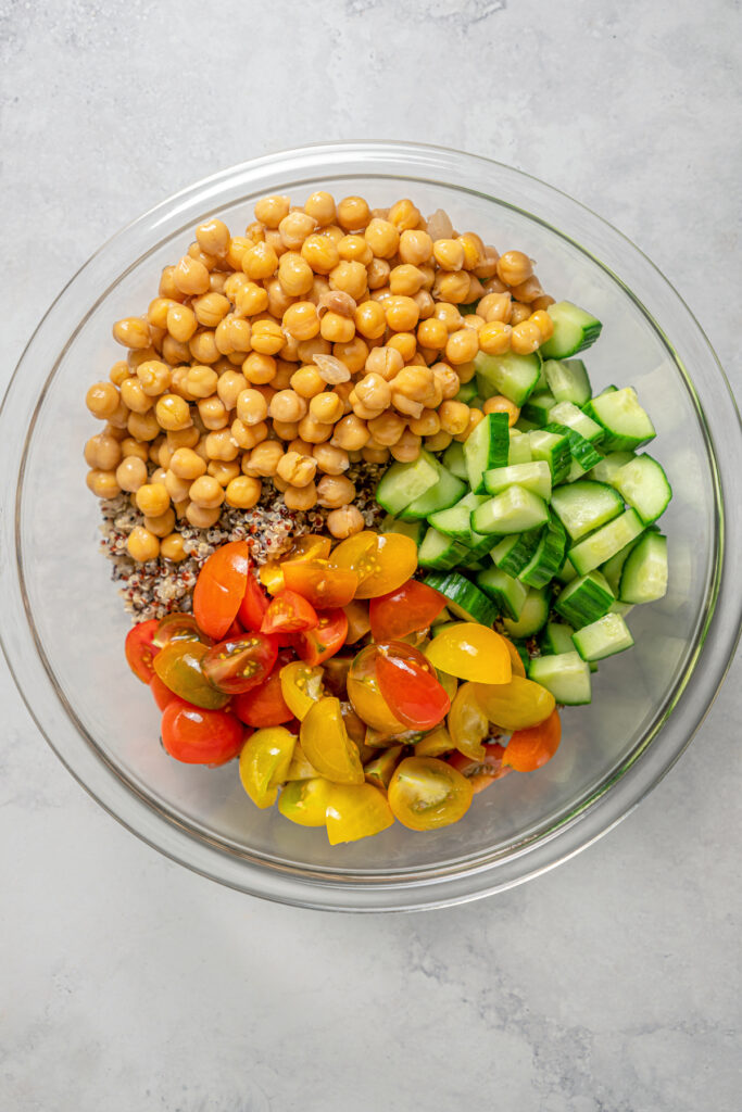 A salad bowl with cucumber, tomato, and chickpeas.