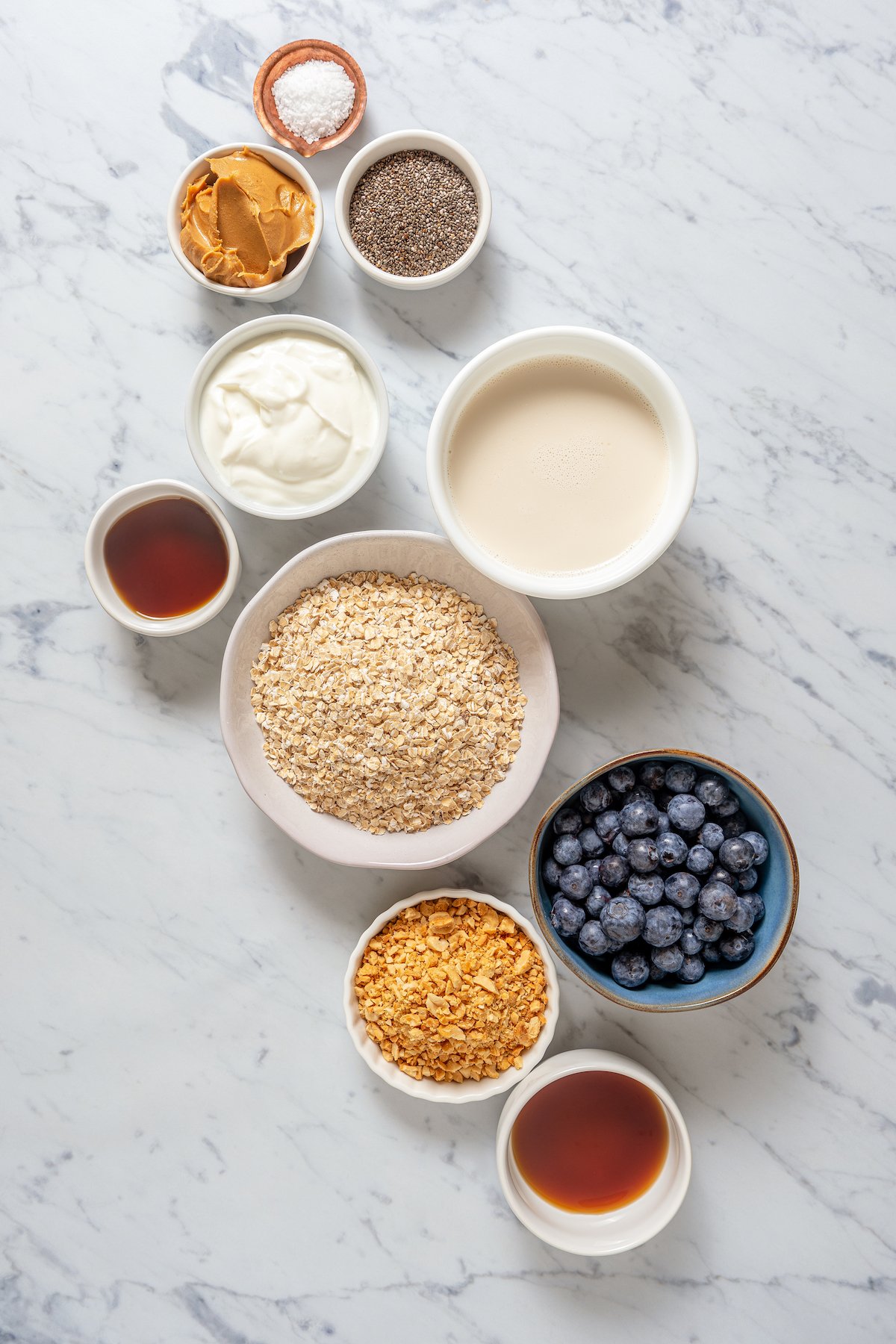 Ingredients for overnight oats, measured and arranged on a work surface.