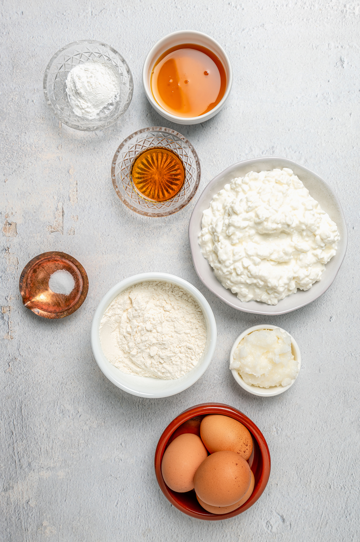 Cottage cheese, gluten free flour, and other baking ingredients arranged on a work surface.