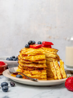 A stack of cottage cheese pancakes with a triangular bite cut out of the whole stack.