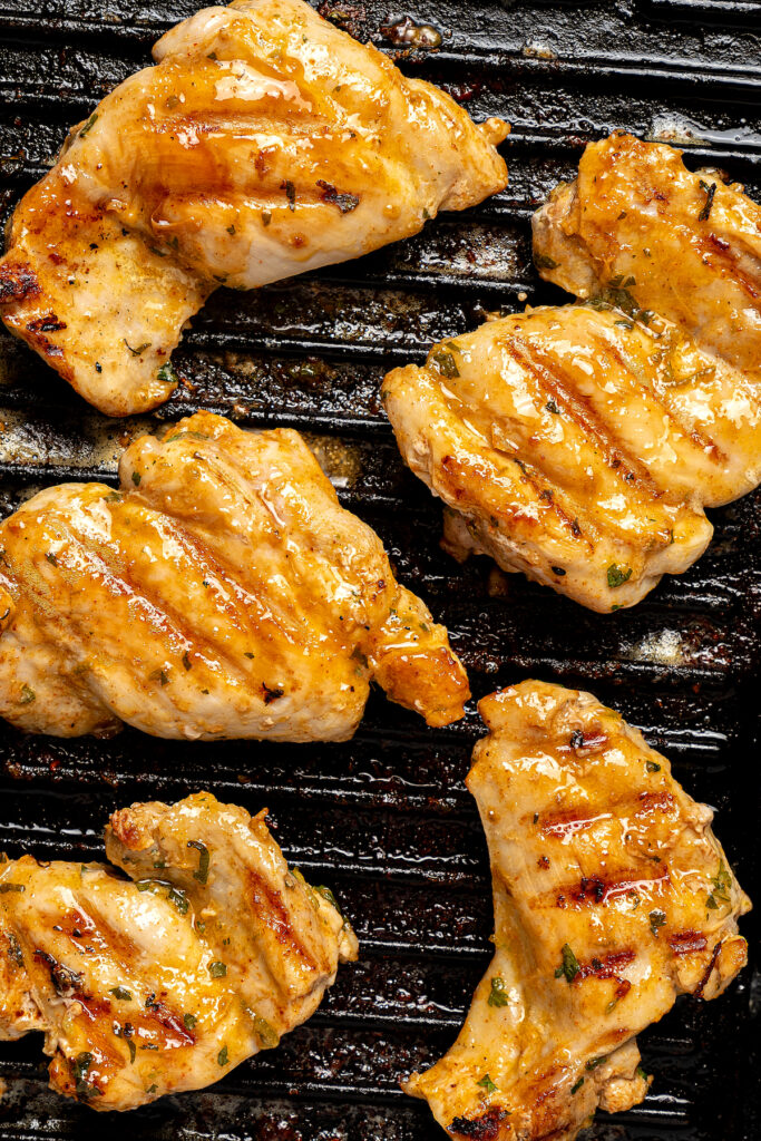 Grilling chicken thighs on a grill pan.