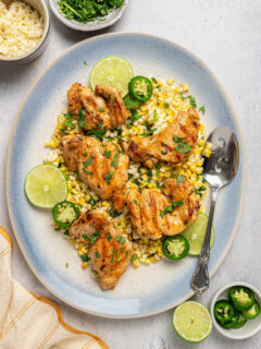 A platter of grilled chicken with Mexican street corn salad.