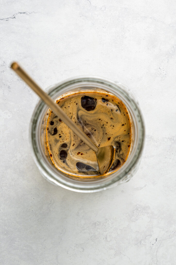 Overhead shot of iced coffee in a glass.