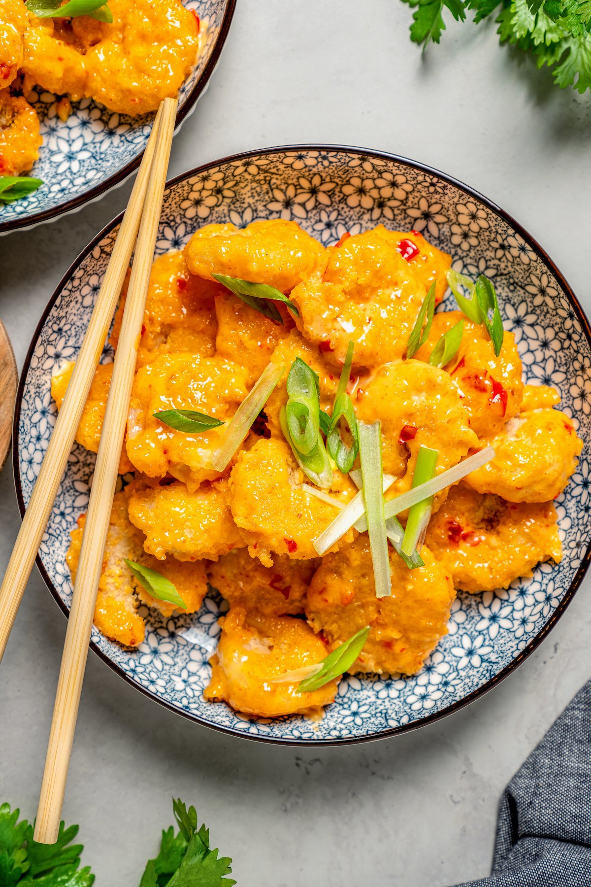 Bowl of boom boom shrimp with chopsticks on the side.