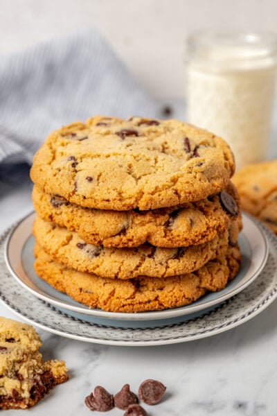 Stack of almond flour chocolate chip cookies with a glass of milk in the background.