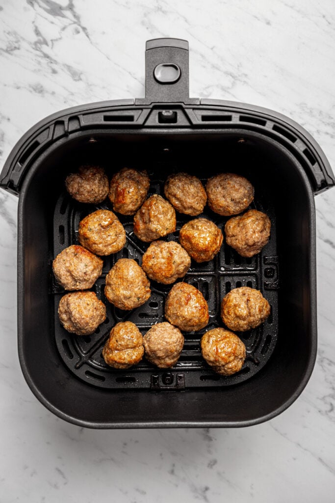 Cooked meatballs in the air fryer basket. 