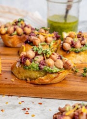 Close-up of chickpea bruschetta with lemon zest and fresh thyme on top.